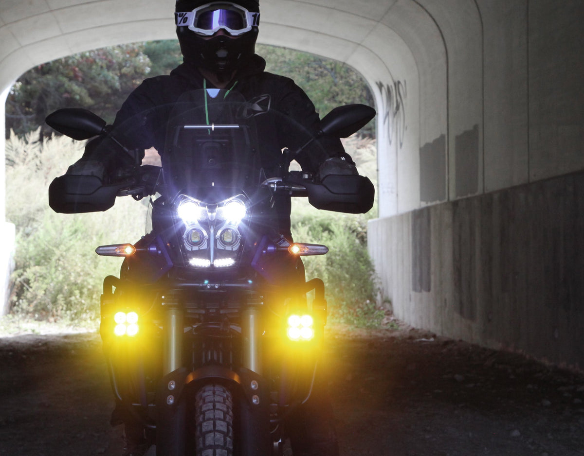 Coppia di faretti DENALI DL4 accesi su moto, vista laterale