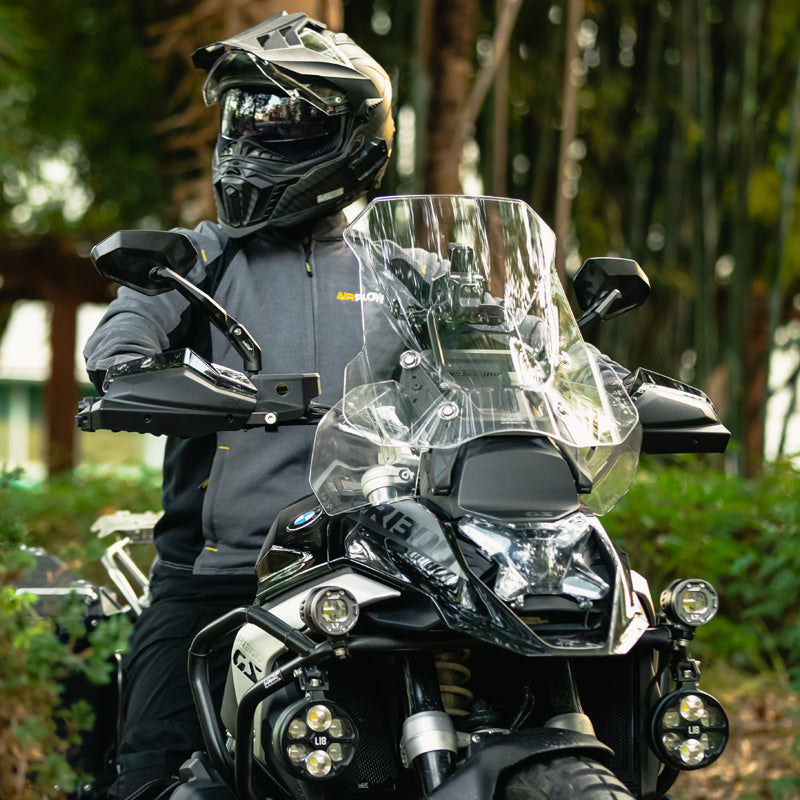 Motociclista accanto alla BMW R 1300 GS con il parabrezza maggiorato trasparente