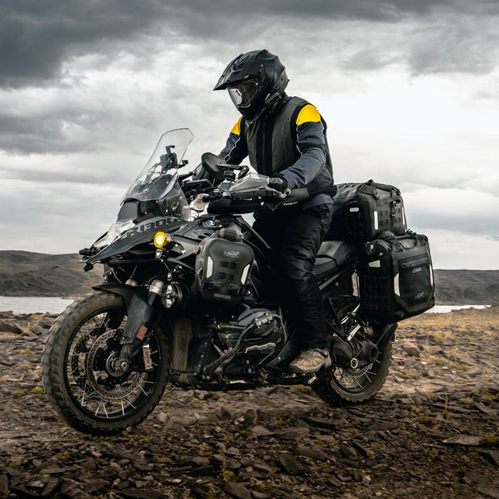 BMW R 1300 GS con valigie laterali gonfiabili e borsone posteriore su sterrato