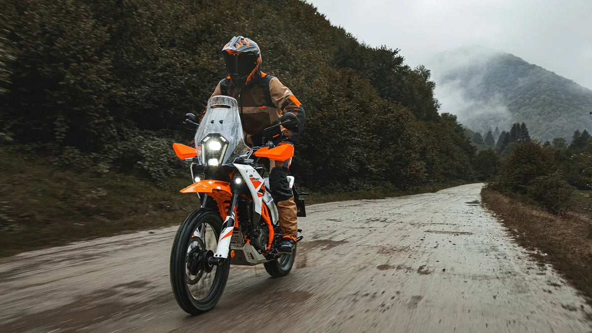 KTM 390 Adventure in fuoristrada su sterrato bagnato con pilota in assetto da viaggio