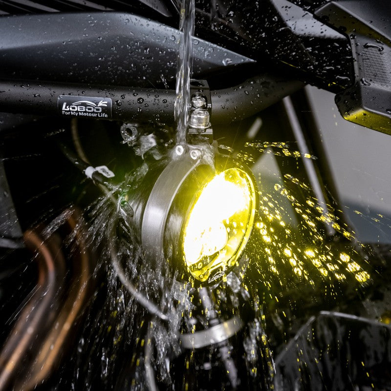 Faro L16 acceso a luce gialla sotto getto d'acqua: tenuta IP68