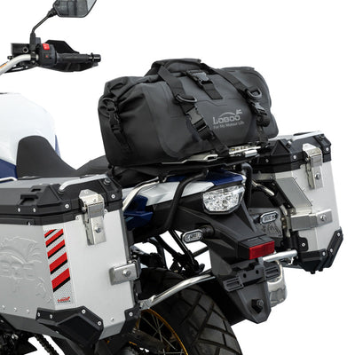 Dettaglio del fissaggio a cinghie della borsa LOBOO da 20 L sul portapacchi di una Suzuki V-Strom 800DE