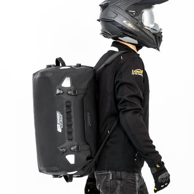Motociclista che indossa la borsa LOBOO ALPS 46 L come zaino, con le doppie spalline allacciate