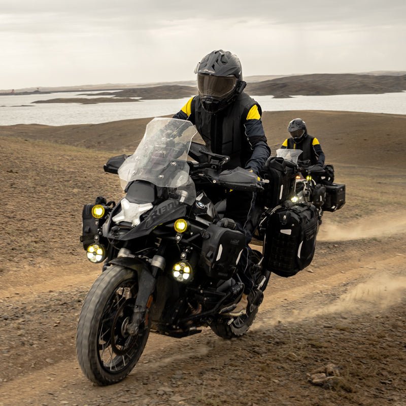 Due moto adventure equipaggiate con valigie laterali LOBOO Alps su pista sterrata