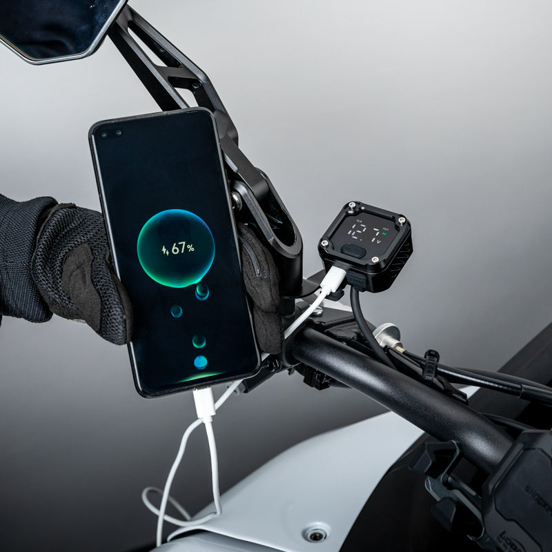 Smartphone in ricarica dal LOBOO C36 durante una sosta, comando con guanto da moto