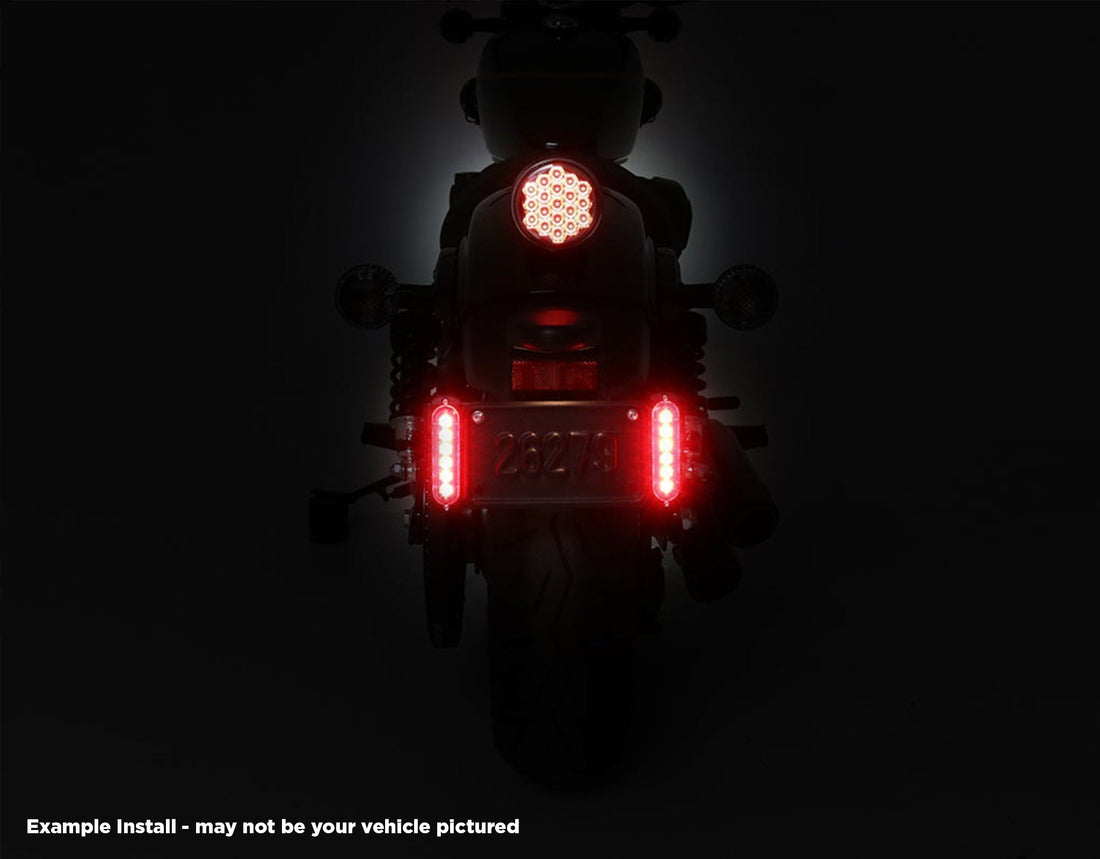Doppia luce freno B6 DENALI accesa ai lati della targa sulla Honda Africa Twin, vista notturna