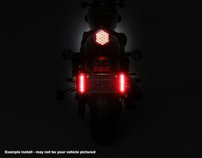 Doppia luce freno B6 DENALI accesa ai lati della targa sulla Kawasaki KLR 650, vista notturna