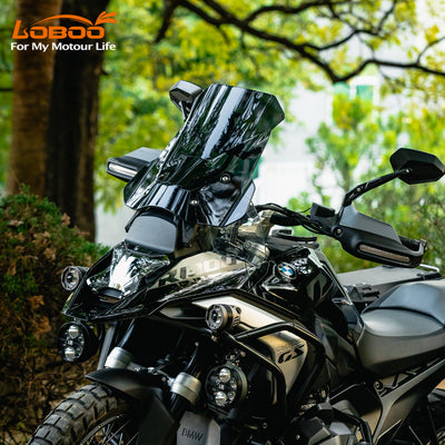 BMW R 1300 GS con il parabrezza maggiorato scuro montato, ambientata nel bosco